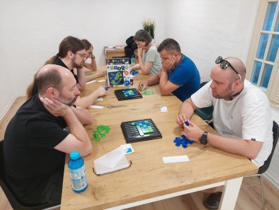 na zdjęciu osoby siedzące przy stolikach, grające w gry planszowe. Kliknij, aby powiększyć zdjęcie.